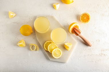 Olgun limonlu kompozisyon ve açık arkaplanda taze meyve suyu bardakları