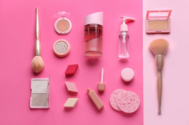 Pembe arka planda farklı kozmetik ürünlerine sahip kompozisyon, üst görünüm