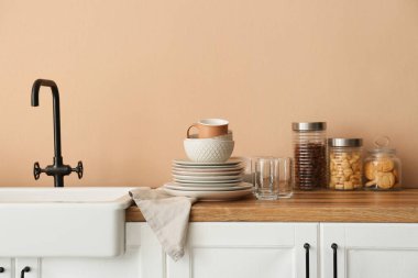 Mutfakta lavabonun yanında temiz sofra takımı var.