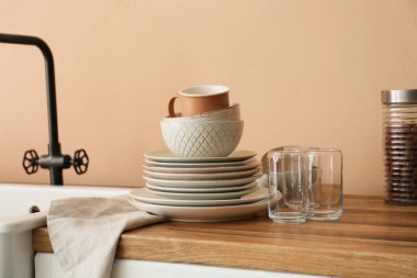 Mutfakta lavabonun yanında temiz sofra takımı var.