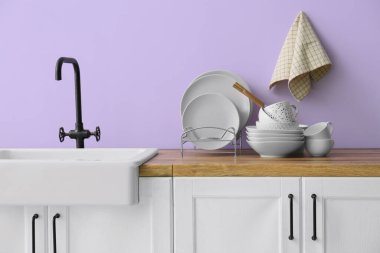 Mutfakta lavabonun yanında temiz sofra takımı var.