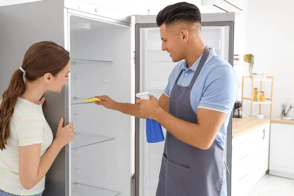 Jovem Casal Limpeza Geladeira Cozinha — Fotografia de Stock