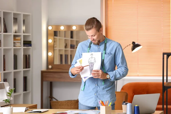 Stüdyoda çalışan genç erkek giyim tasarımcısı.