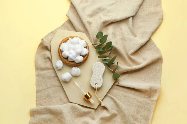 Renk arkaplanındaki pamuk topları ve okaliptüs dallarıyla kompozisyon