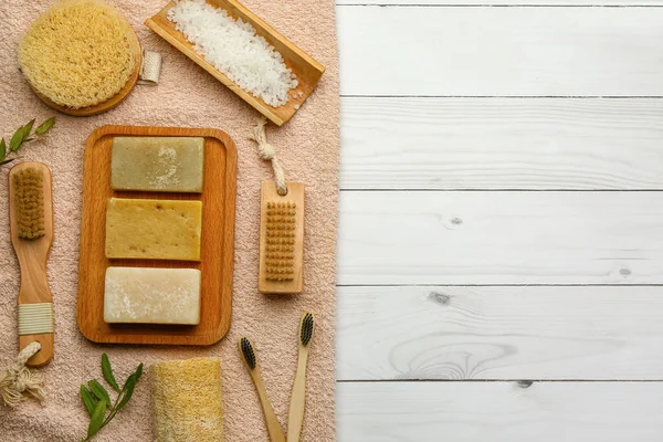 Hafif ahşap arka planda sabun kalıplı banyo malzemeleri.