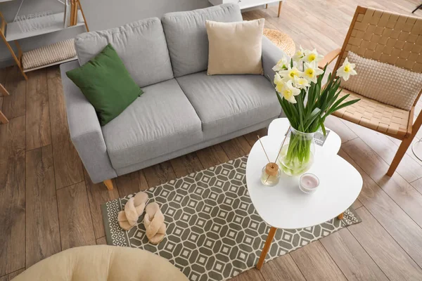 Nergisli vazo ve kamış ayırıcı modern oturma odasındaki masada.