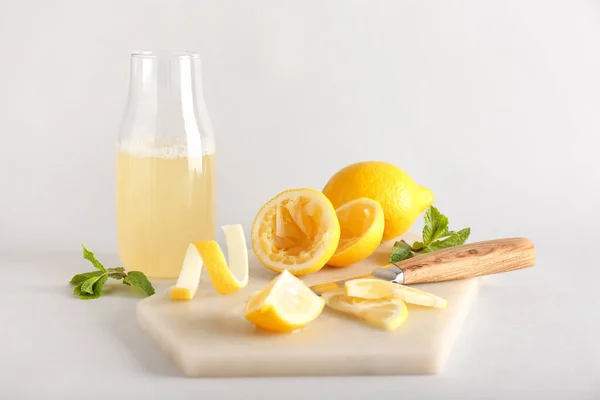 Tablero Con Limones Cortados Botella Jugo Sobre Fondo Claro —  Fotos de Stock