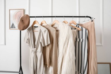 Modern moda stilistinin stüdyosunda şık kıyafetlerle dolu raflar.