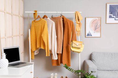 Modern moda stilistinin stüdyosunda şık kıyafetlerle dolu raflar.