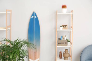 Sörf tahtası, askısı ve saksısı olan modern tarz bir oda.