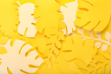 Sarı arka planda kağıt tropikal yapraklar