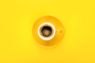 Sarı arka planda bir fincan sıcak kahve