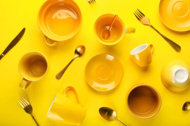 Sarı zemin üzerinde çatal bıçak takımı olan temiz sofra takımı.