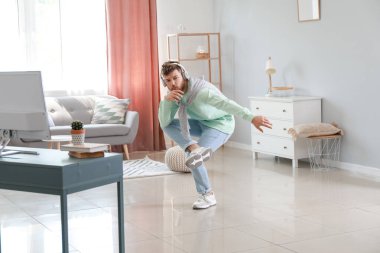 Havalı genç adam evde dans etmeyi öğreniyor.