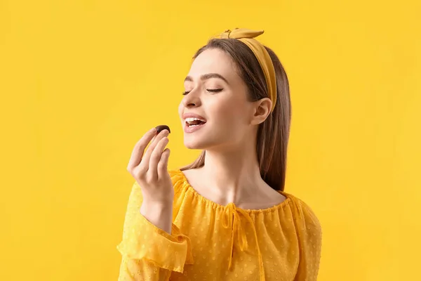 Schöne Junge Frau Mit Leckeren Schokoladenbonbons Auf Farbigem Hintergrund — Stockfoto