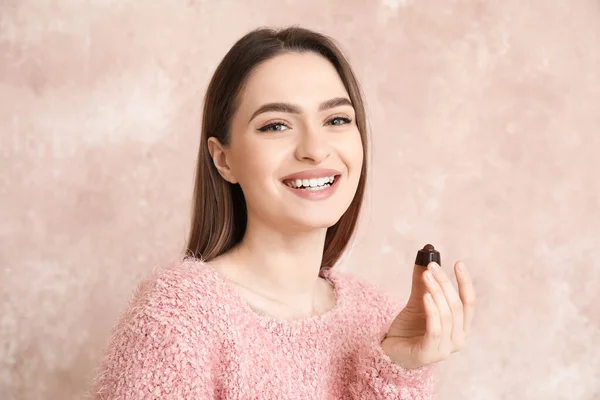Renkli Arkaplanda Çikolata Şekerleri Olan Güzel Genç Bir Kadın — Stok fotoğraf