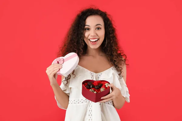 Happy Jonge Vrouw Met Heerlijke Chocolade Snoepjes Doos Kleur Achtergrond — Stockfoto