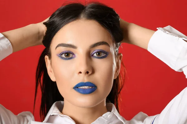 Hermosa Joven Con Maquillaje Creativo Sobre Fondo Rojo — Foto de Stock