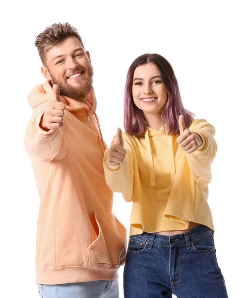 Beyaz arka planda baş parmak gösteren kapüşonlu havalı genç çift.