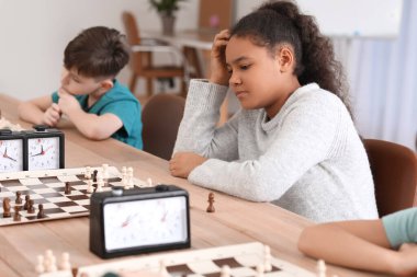 Kulüpte turnuvada satranç oynayan küçük çocuklar.