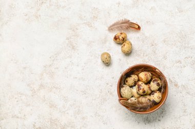 Arka planda taze bıldırcın yumurtaları olan bir kase.