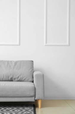 Beyaz duvarın yanındaki modern kanepe.