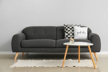 Modern kanepe ve ışık duvarının yanındaki masa.