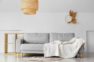 Modern kanepe ve beyaz duvarın yanındaki masa.