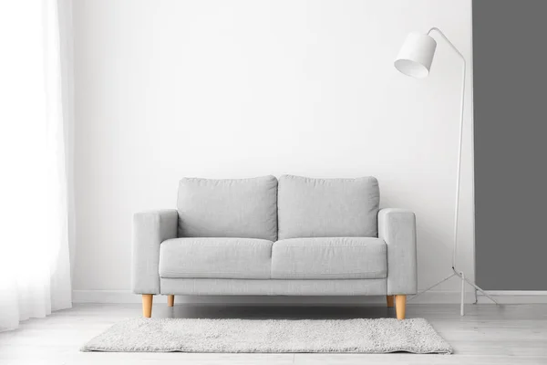 Sofá Elegante Lâmpada Perto Parede Branca — Fotografia de Stock