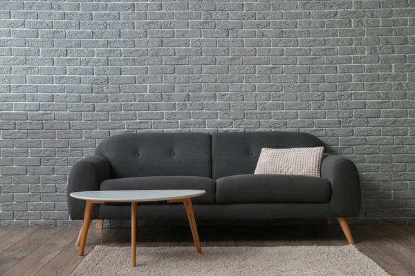 Stilvolles Sofa Und Tisch Der Nähe Der Grauen Ziegelwand — Stockfoto