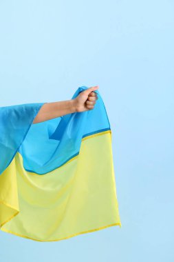 Renkli arka planda Ukrayna bayrağına sahip kadın eli