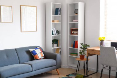 Işık duvarındaki boş posterler ve oturma odasındaki kanepe.