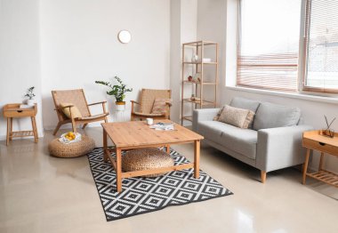 Kanepesi ve tahta koltukları olan aydınlık oturma odasının içinde.