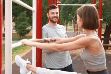 Genç bir adam ve karısı spor sahasında