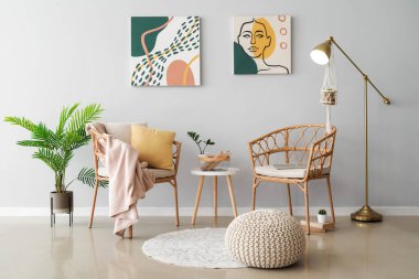 Hasır sandalyeli, masa ve ayakta duran lambasıyla aydınlık oturma odasının içinde.