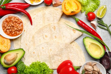 Tortilla ve hafif arka planda lezzetli dürüm hazırlamak için taze malzemeler.