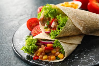 Siyah arka planda eti olan lezzetli dürümler.