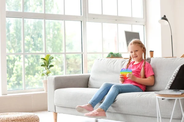 Girl Sitting Sofa Holding Pop Fidget Toy Light Room — Stock Photo, Image
