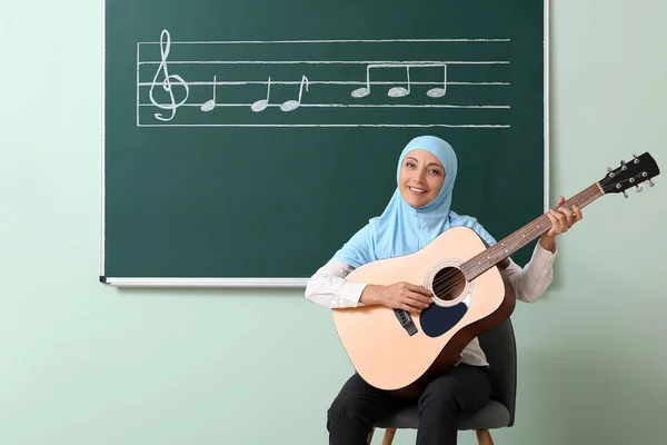 Muselman Musik Lärare Med Gitarr Nära Svarta Tavlan Klassrummet — Stockfoto
