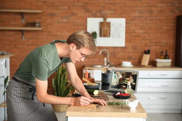 Schöner Junger Mann Macht Sich Notizen Aus Kochvideo Anleitung Küche — Stockfoto