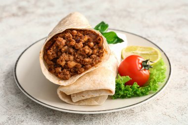 Hafif arka planda lezzetli burritoları olan tabak, yakın plan.