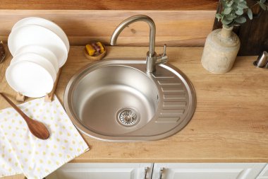 Ahşap duvarın yanında vazo ve yemek takımı olan tezgah.