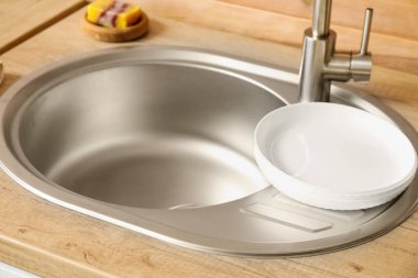 Lavabo ve tabaklarla ahşap tezgah, yakın plan.