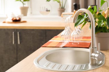 Mutfakta gümüş lavabosu olan ahşap tezgah.