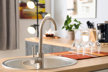 Mutfakta gümüş lavabosu olan ahşap tezgah.