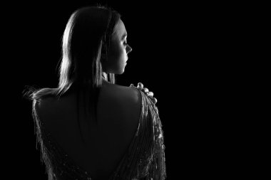 Siyah arka planda çekici genç bir kadının silueti, siyah beyaz efekt