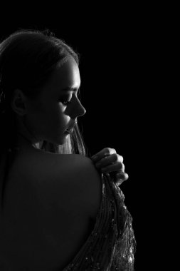 Siyah arka planda çekici genç bir kadının silueti, siyah beyaz efekt