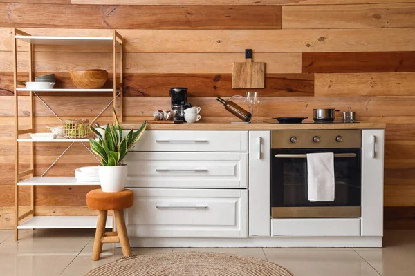 厨房木墙附近装有餐具 台子和家居用品的现代架子 — 图库照片