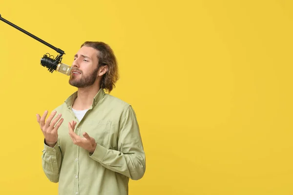 Bonito Jovem Cantando Microfone Fundo Amarelo — Fotografia de Stock