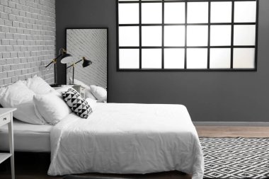 Lambalı ve aynalı şık bir yatak odası.